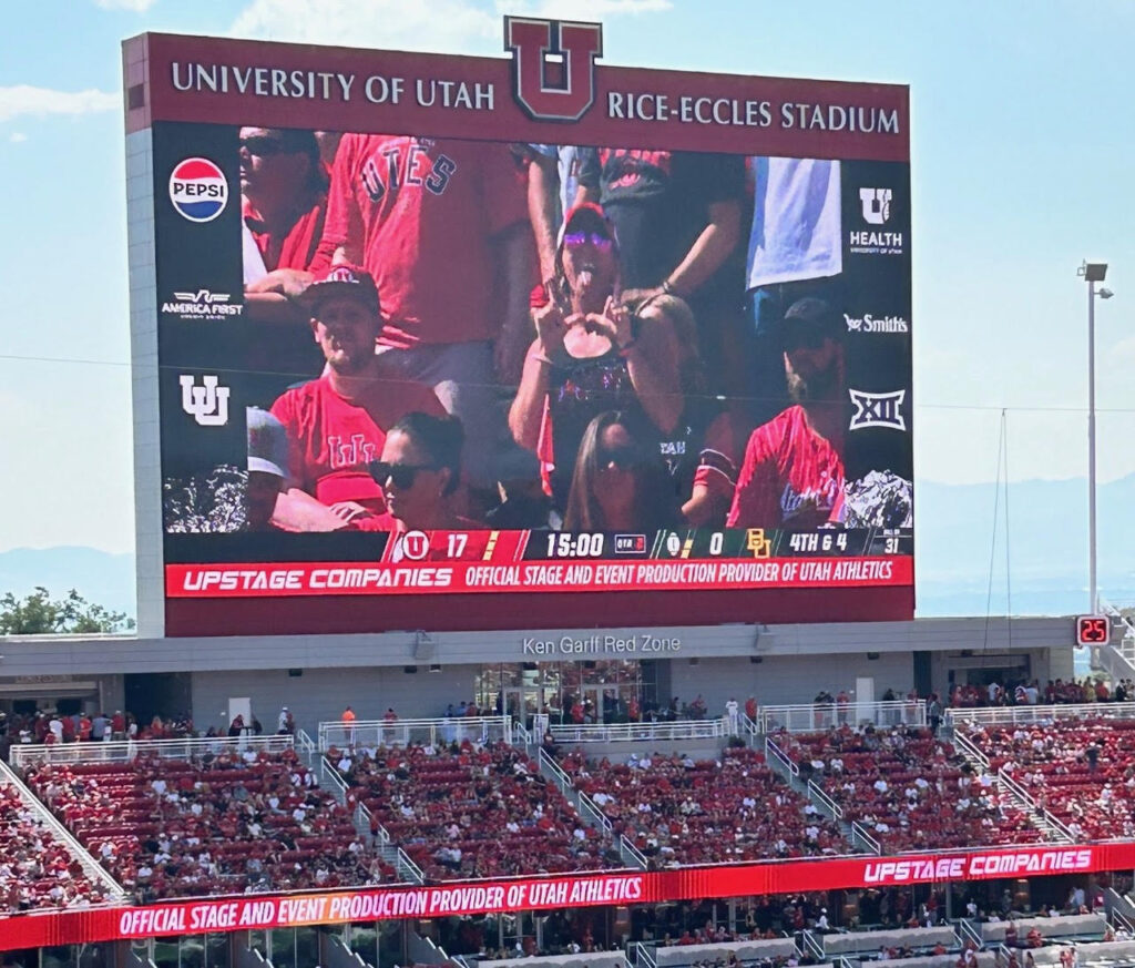 people on the big screen at the University of Utah stadium